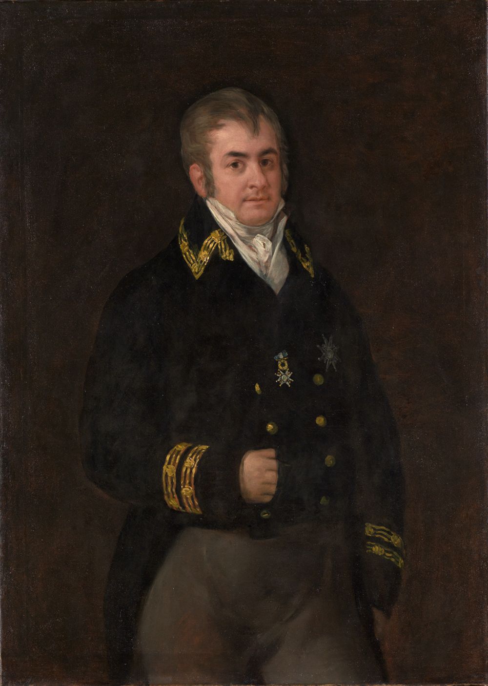 Francisco de Goya zeigt einen Mann, der in eleganter Kleidung vor einem neutralen Hintergrund steht. Der Mann ist in einer selbstbewussten, fast herausfordernden Haltung dargestellt.