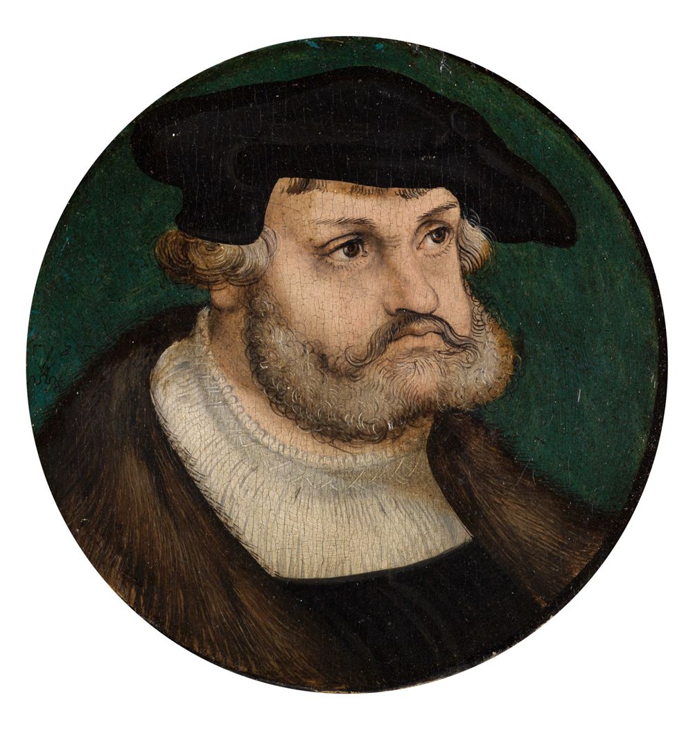 Das Bild von Lucas Cranach zeigt einen Mann im Brustbild in einem eleganten Gewand mit einem Hut und einem Mantel aus kostbaren Stoffen.