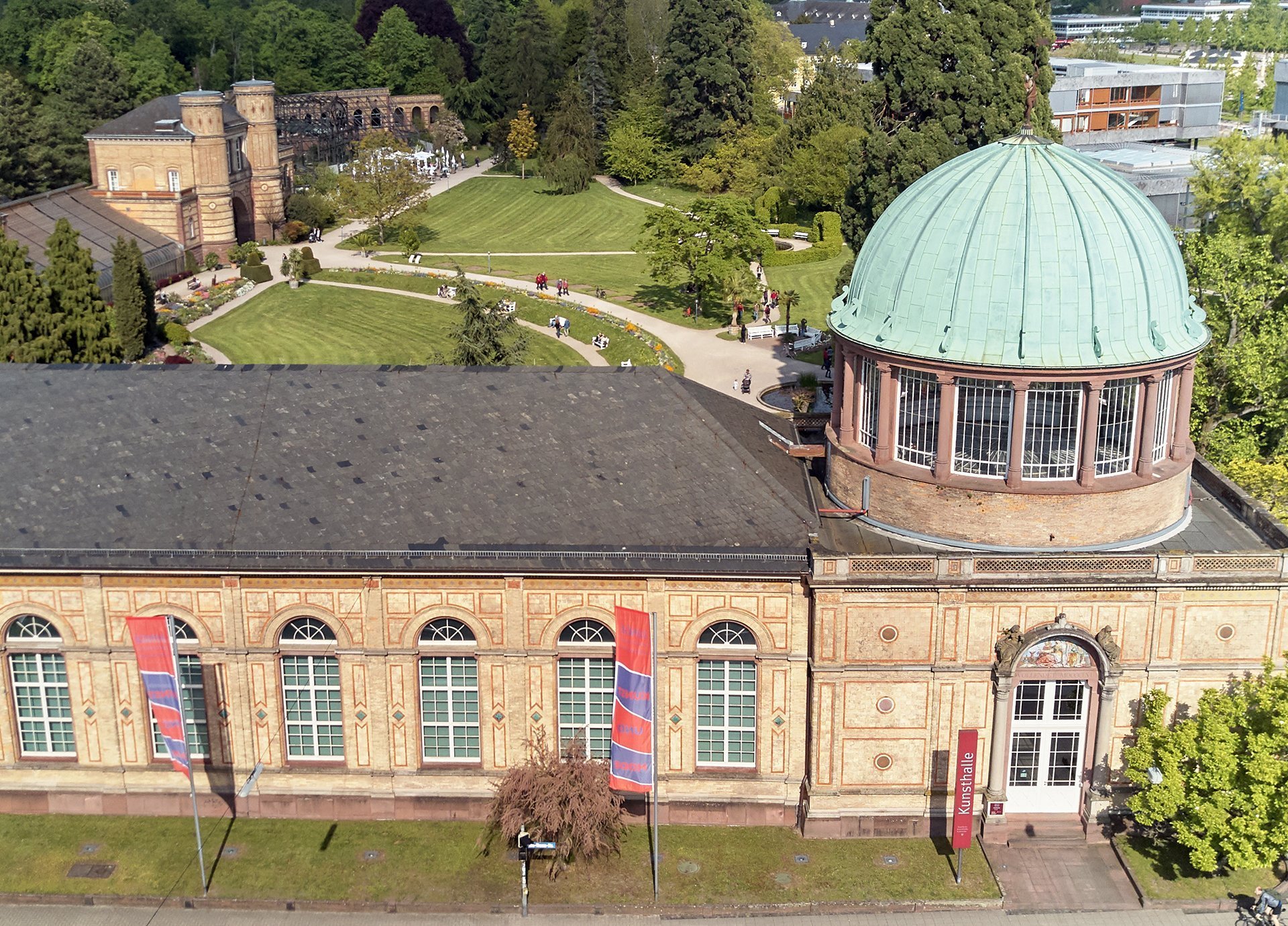 Foto der von Heinrich Hübsch erbauten Orangerie mit der Kuppel. Es handelt sich um eine Drohnenaufnahme.