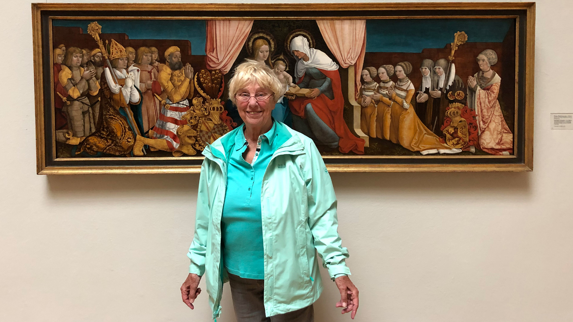 Foto einer Besucherin, die schon vor 60 Jahren die letzte große Baldung Retrospektive der Kunsthalle besuchte. Sie steht vor einem rechteckigen alten Gemälde.