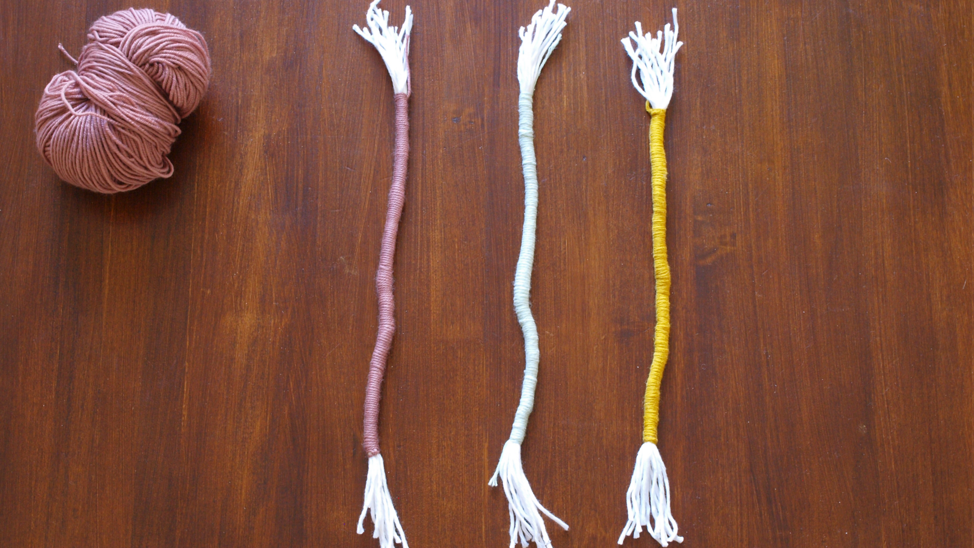 Alle Stränge gleichmäßig mit Wolle in je einer Farbe umwickeln.