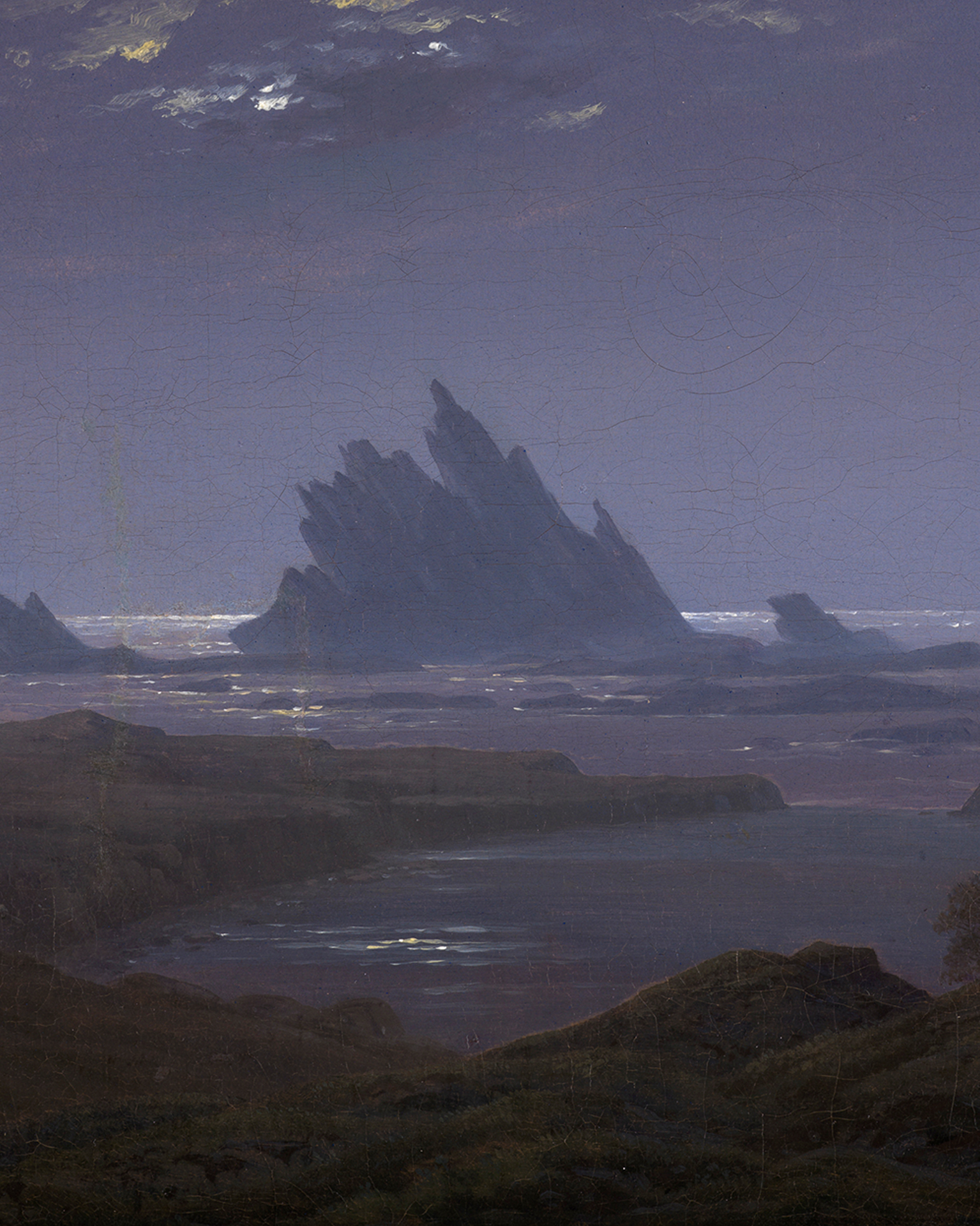 Caspar David Friedrichs Felsenriff am Meeresstrand. Zu sehen ist ein schroffer Felsen, der spitz aus dem Meer ragt.