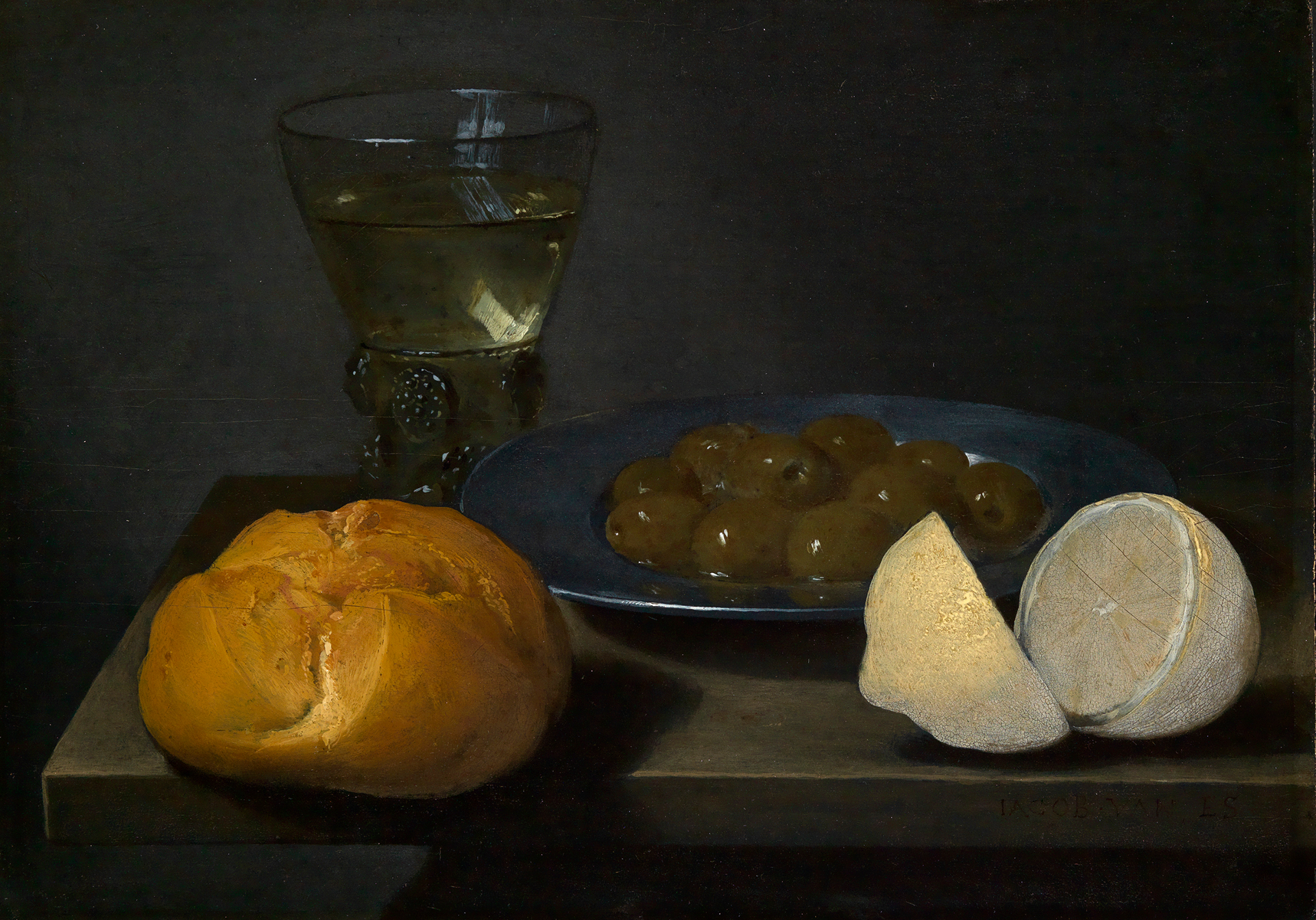 Frühstücksstilleben von Jacop Foppens van Es. Zu sehen ist ein Tisch mit einem Teller mit Oliven. Vor dem Teller ist ein Brötchen und eine aufgeschnittene Zitrone. Hinter dem Teller steht ein Glaspokal.