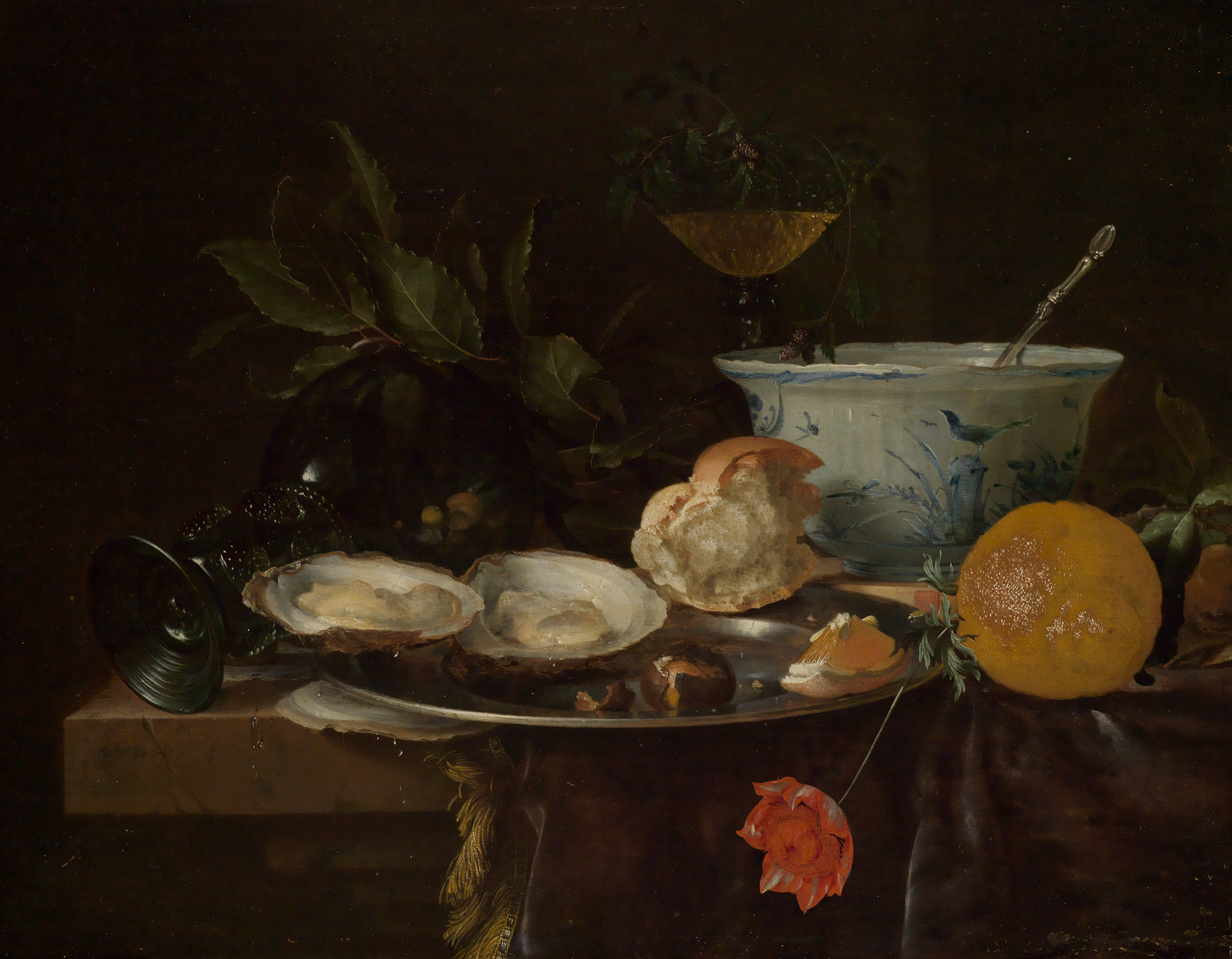 Frühstücksstilleben von Willem Claesz. Heda. Es zeigt einen Tisch mit einem Tablett mit Austern und einem halb aufgegessen Brötchen. Im Vorderrund liegt eine Zitrone und eine Blume. Im Hintergrund ist eine weiß-blaue Schale.