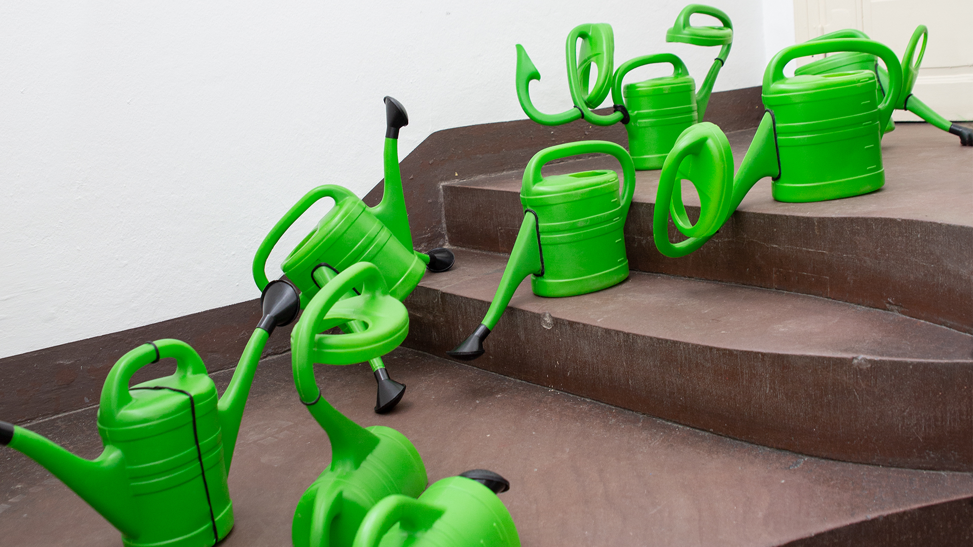 Installation aus grünen Gießkannen im Treppenhaus der Jungen Kunsthalle von Das Änderungsatelier, entstanden 2020.