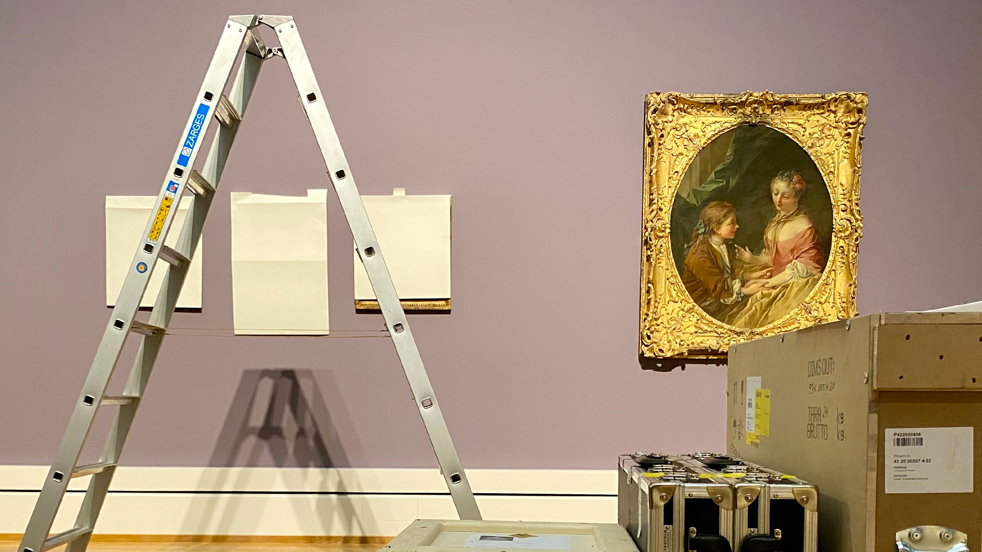 Blick in den Aufbau der Boucher-Ausstellung, mit einigen Kisten, einer Leiter und einem Gemälde