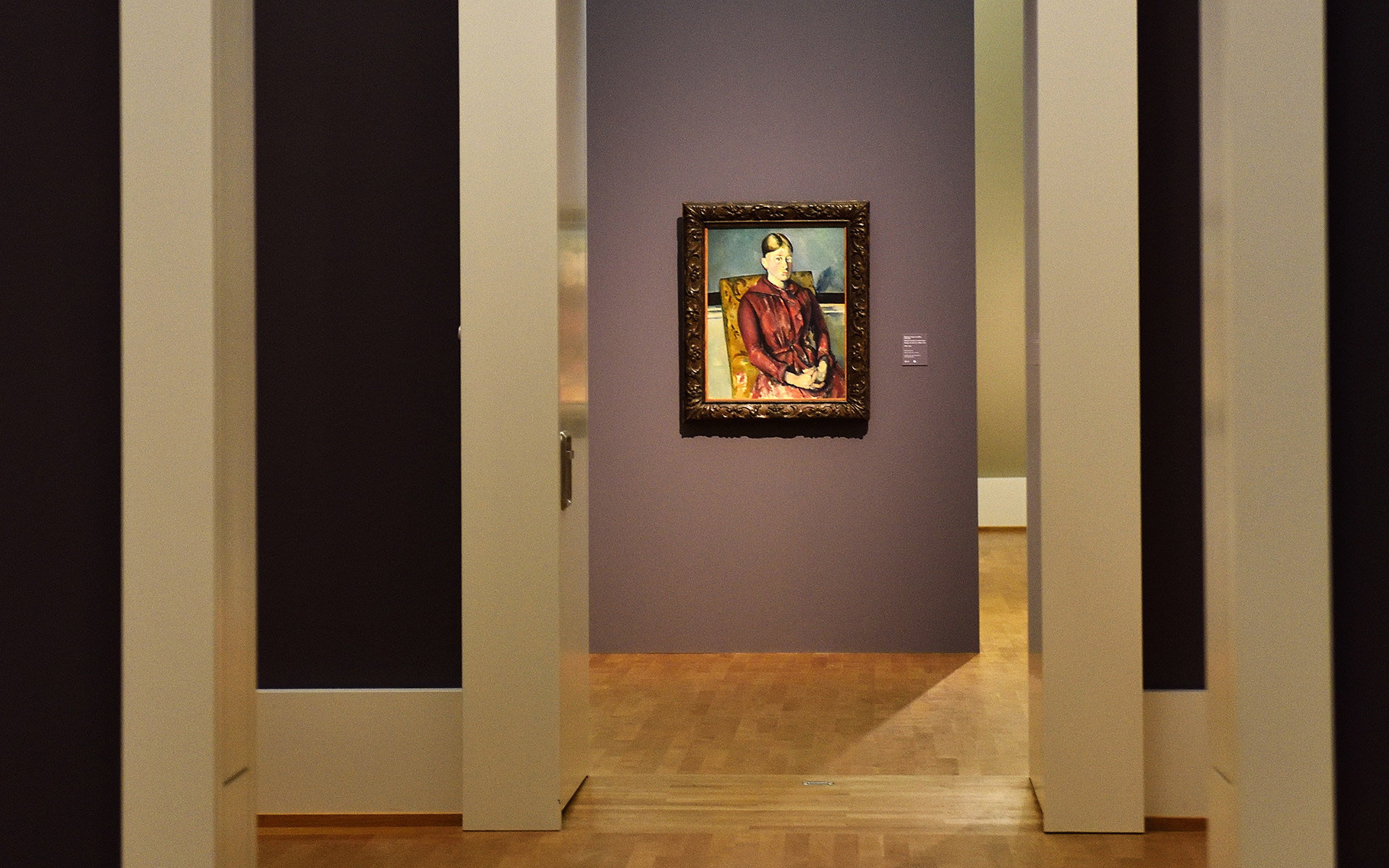 Durchblick durch mehrere Räume. am Ende ist ein Gemälde mit einer Frau in einem roten Kleid zu sehen.