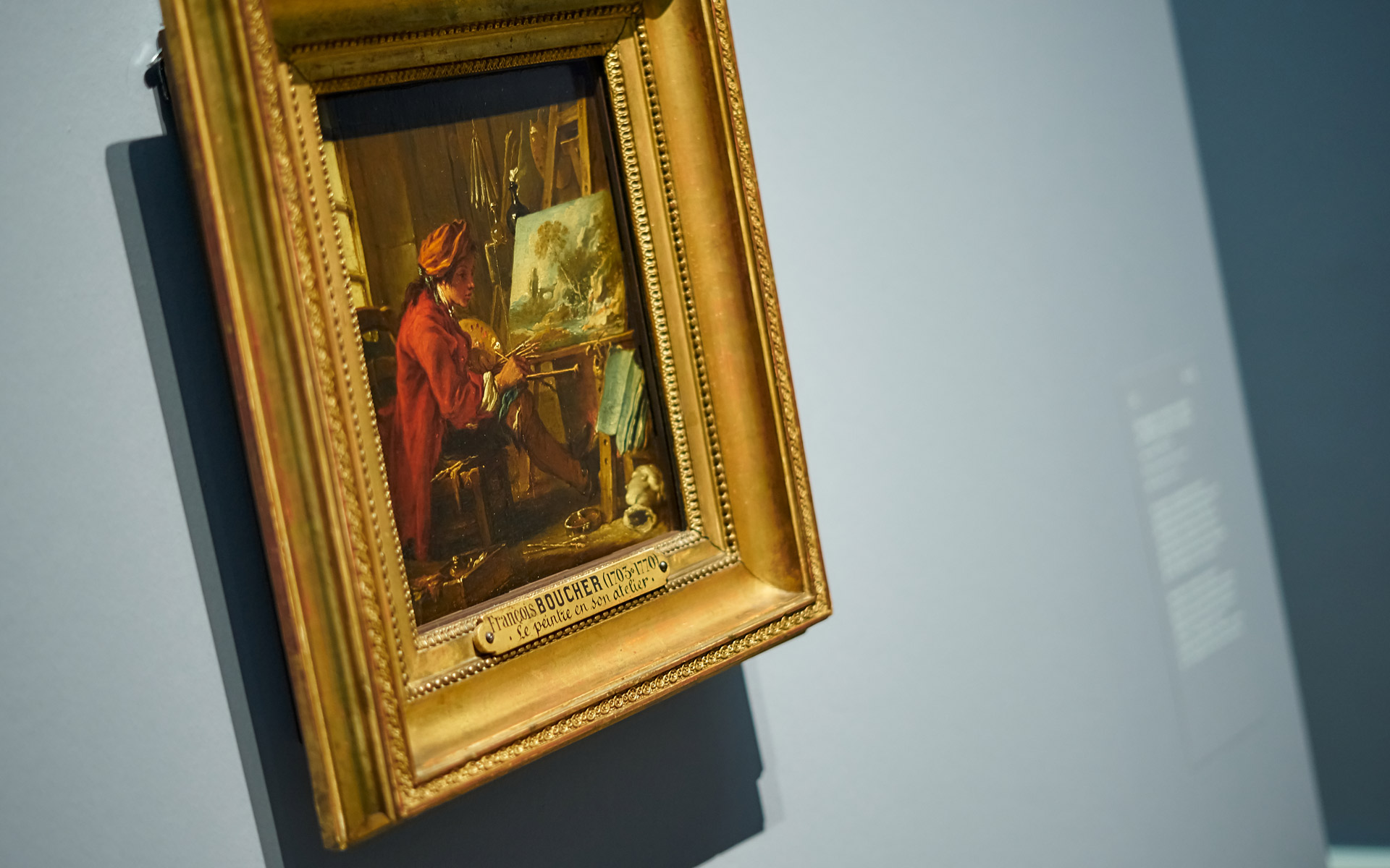 Gemälde Der Maler in seinem Atelier in der Ausstellung François Boucher der Kunsthalle Karlsruhe. Zu sehen ist das Werk an der Wand hängend. Es ist in einem Goldrahmen.