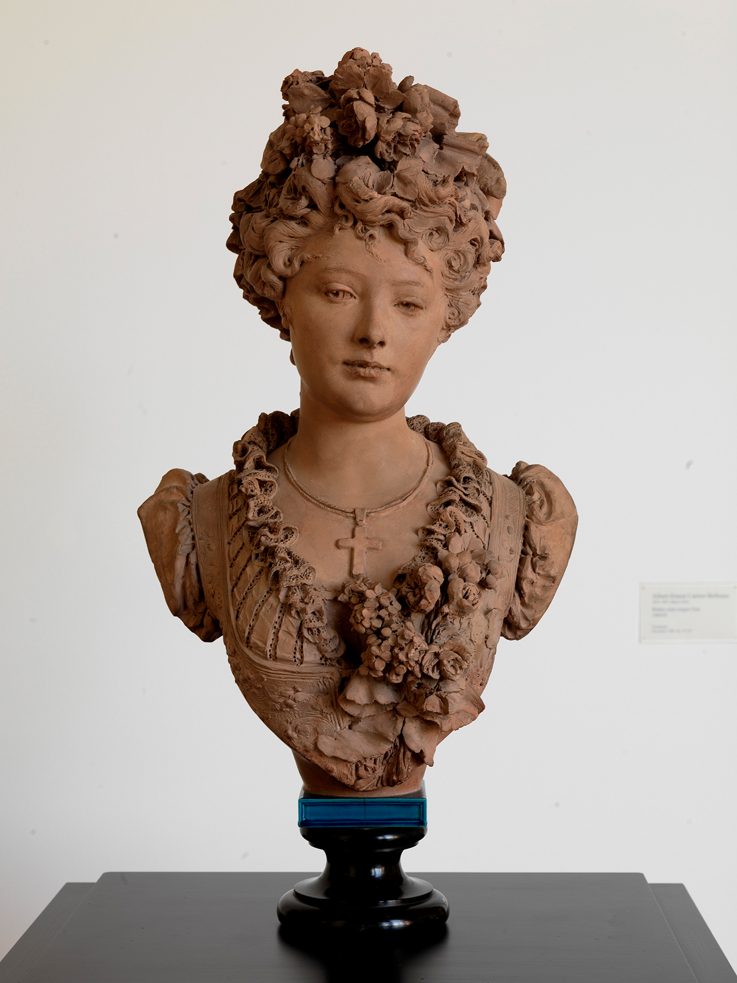 Fotografie einer Skulptur einer jungen Frau, deren Haar und Dekollete mit Blumen verziert ist