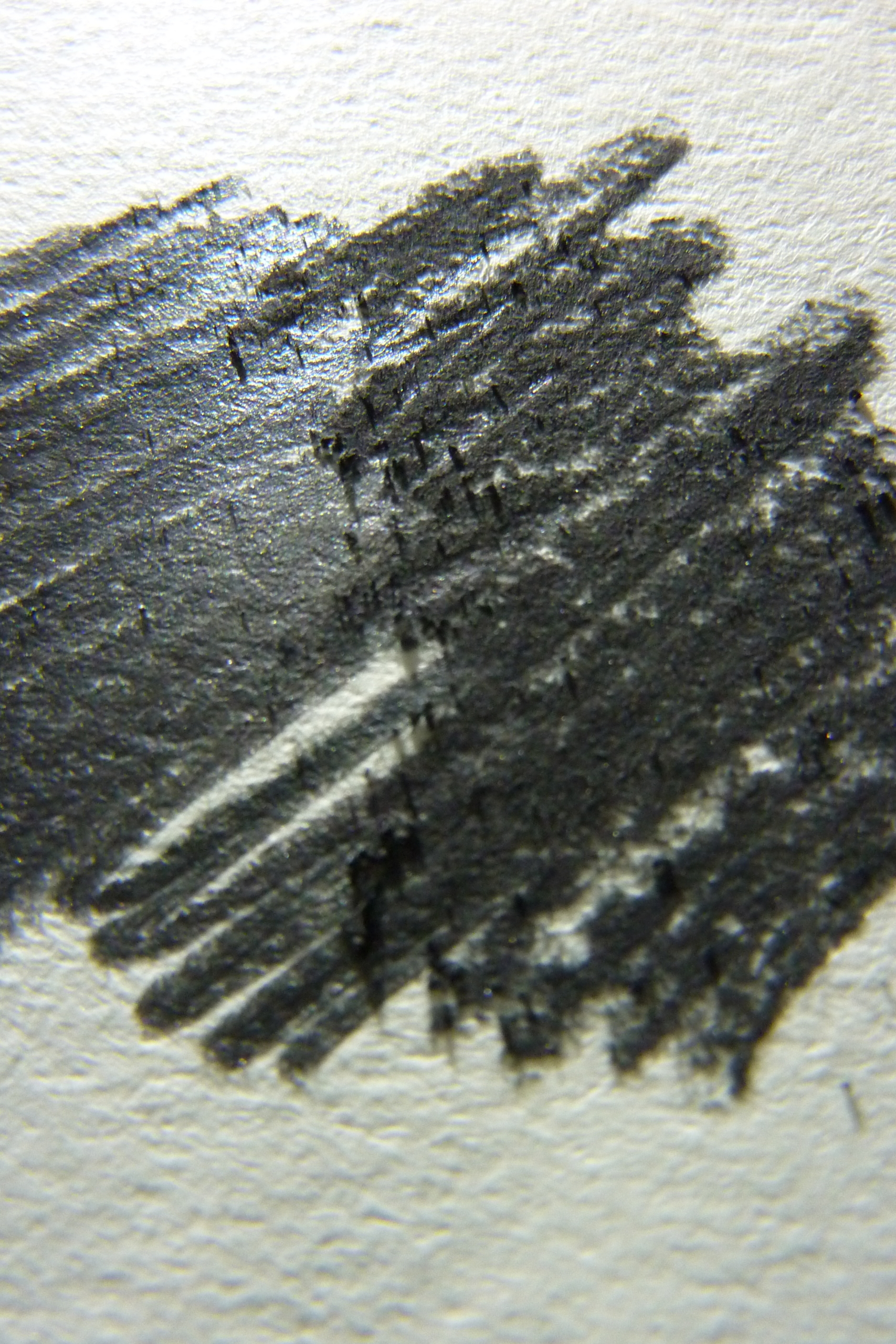 Das Bild zeigt das Aussehen von Graphit und dessen metallischer Glanz auf Papier.