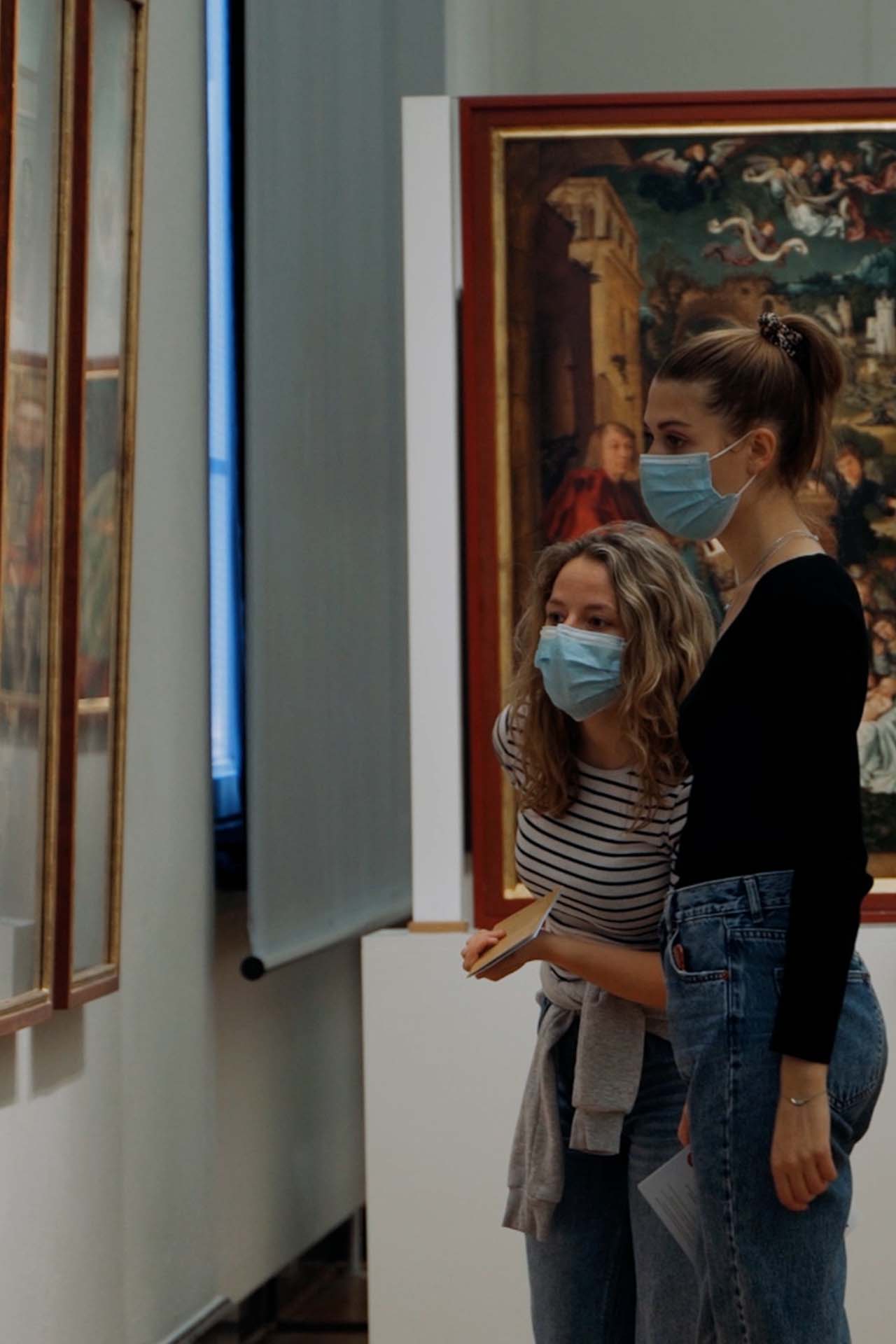 Zwei junge Frauen, die sich ein Bild in der mittelalterlichen Sammlung der Kunsthalle ansehen