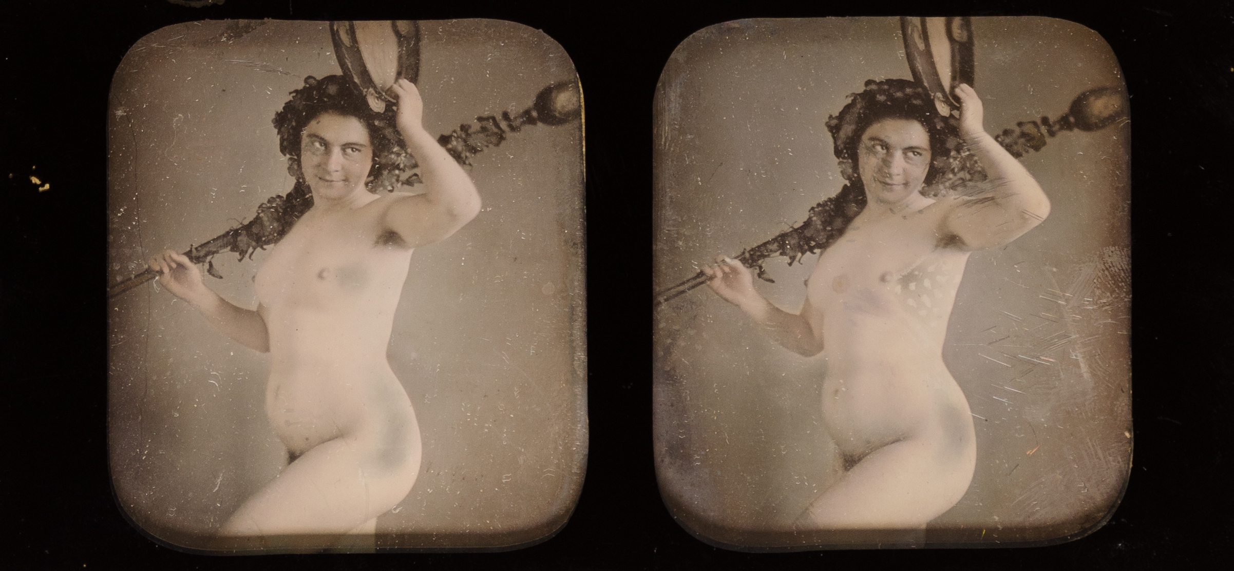 Die Abbildung zeigt zwei gleiche Sepia-Fotografien. Auf beiden ist eine nackte Frau mit Blumenkopfschmuck und einem Stab in der Hand. sind gelich