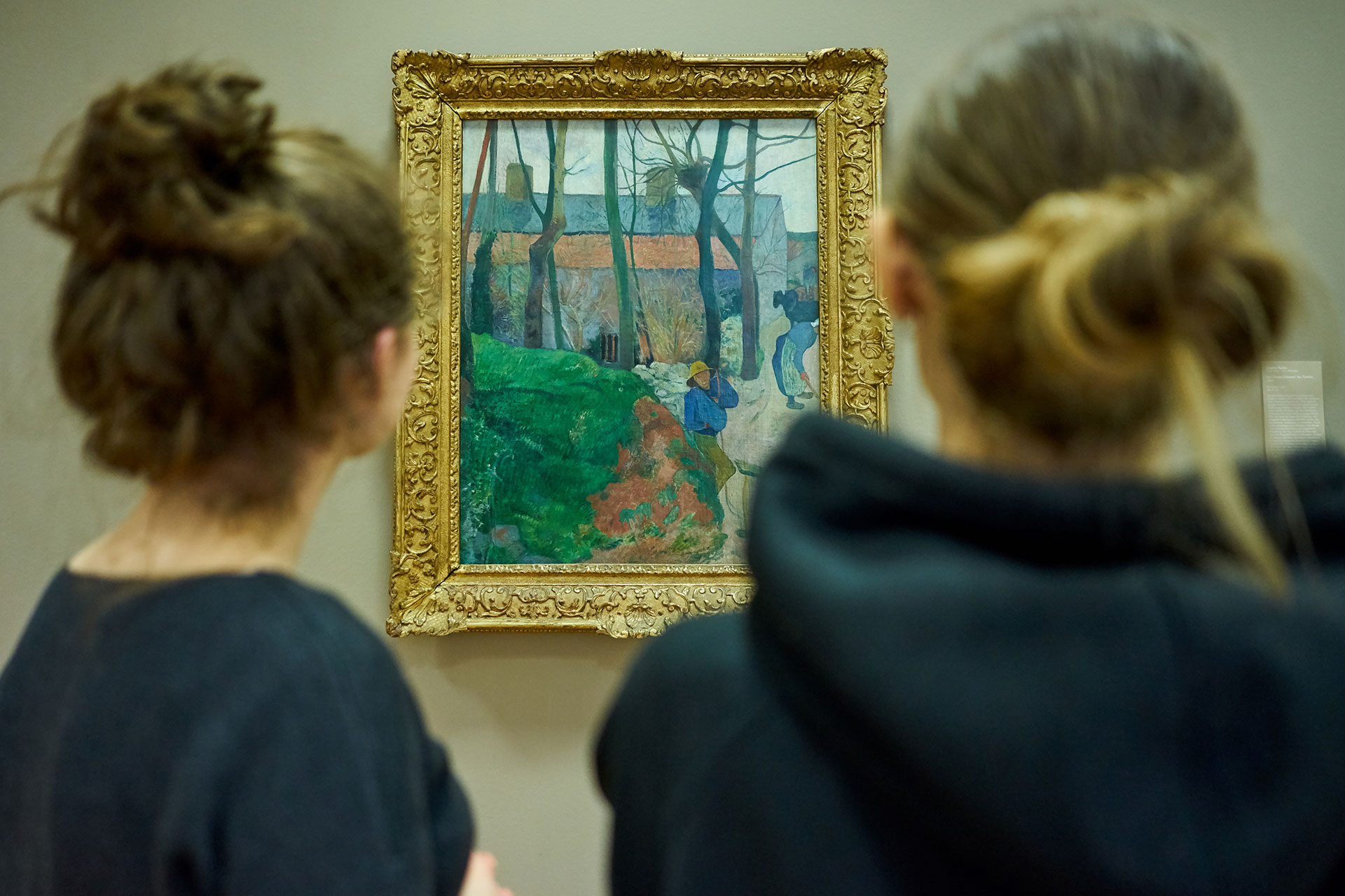 Zwei junge Frauen betrachten Paul Gauguins Gemälde Häuser in Le Pouldu