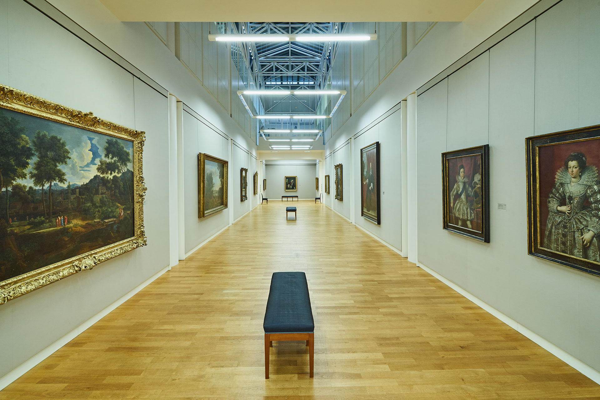 Oberlichtsaal der Kunsthalle Karlsruhe mit einem langen Gang an dessen Wänden Kunstwerke hängen.