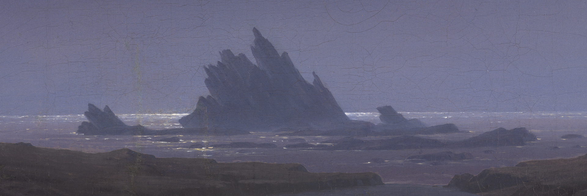 Detail aus Caspar David Friedrichs Felsenriff am Meeresstrand. Ein schroffer Felsen ragt aus dem vom Mondlicht beschienenen Meer hervor.