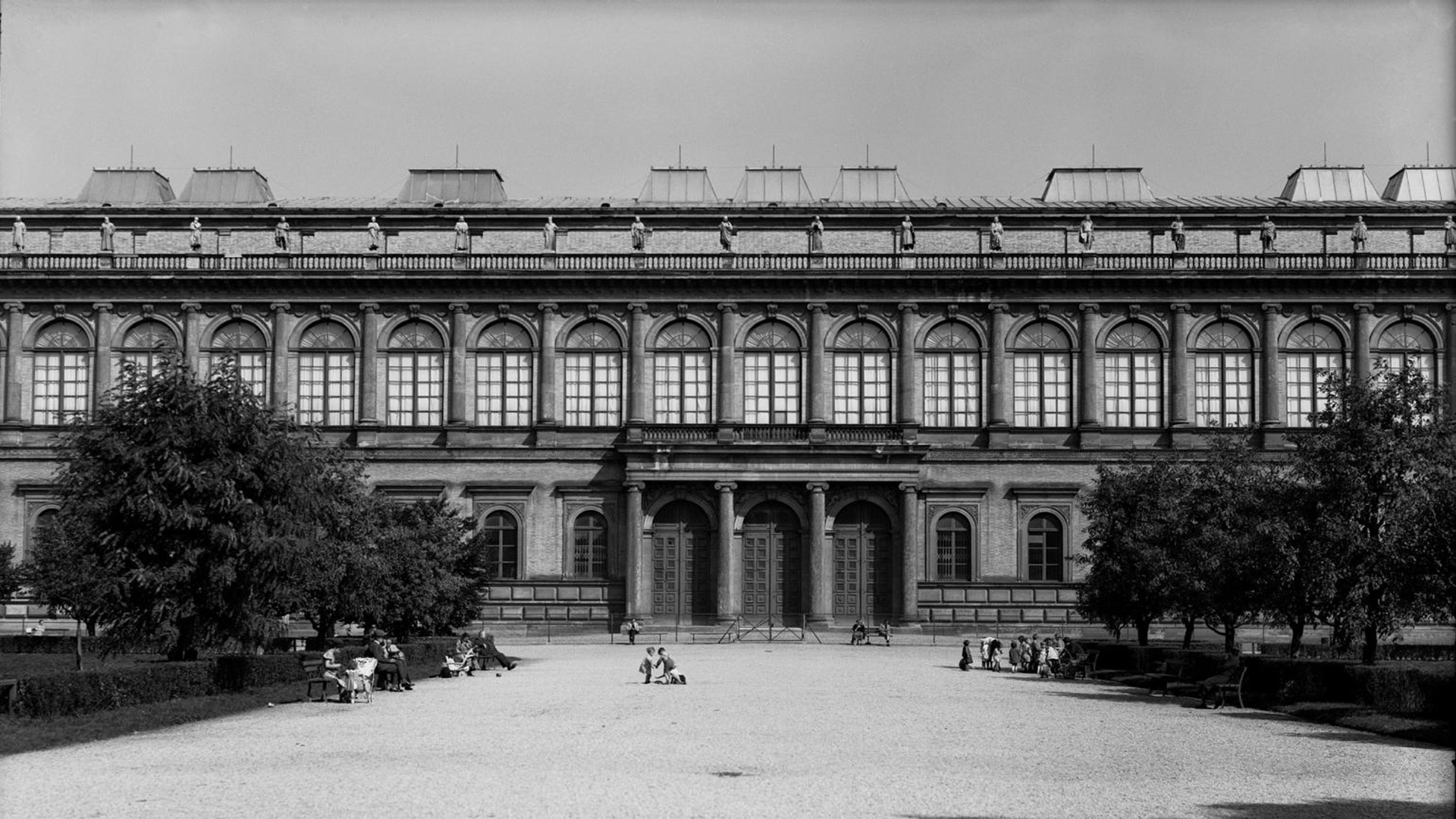 Black-and-white photograph of the south façade of the Alte Pinakothek in Munich from 1938. Figures are lined up on the balustrade.