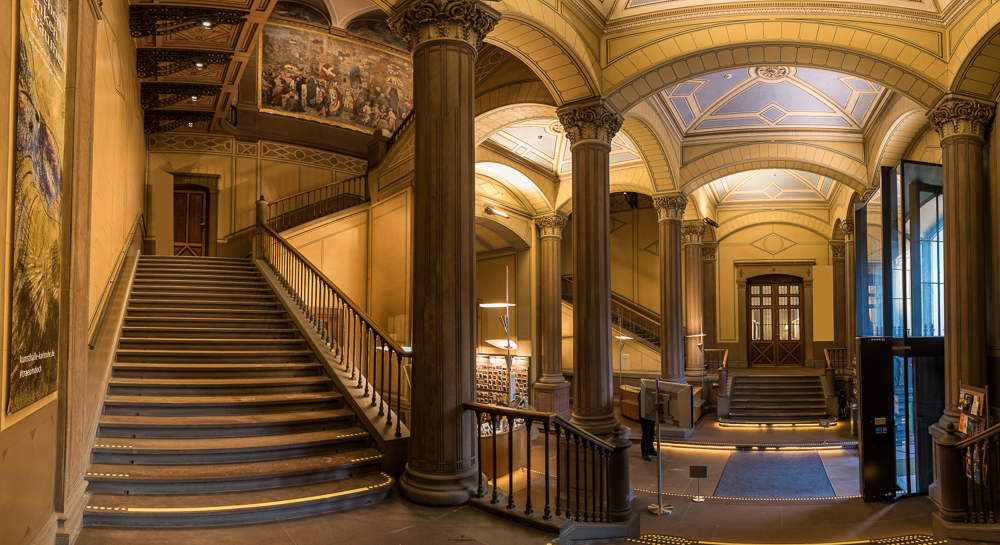 Blick auf das Treppenhaus und den Eingangsbereich der Staatlichen Kunsthalle Karlsruhe, mit Säulen, Deckenmalereien und dem Fresko von Moritz Schwind