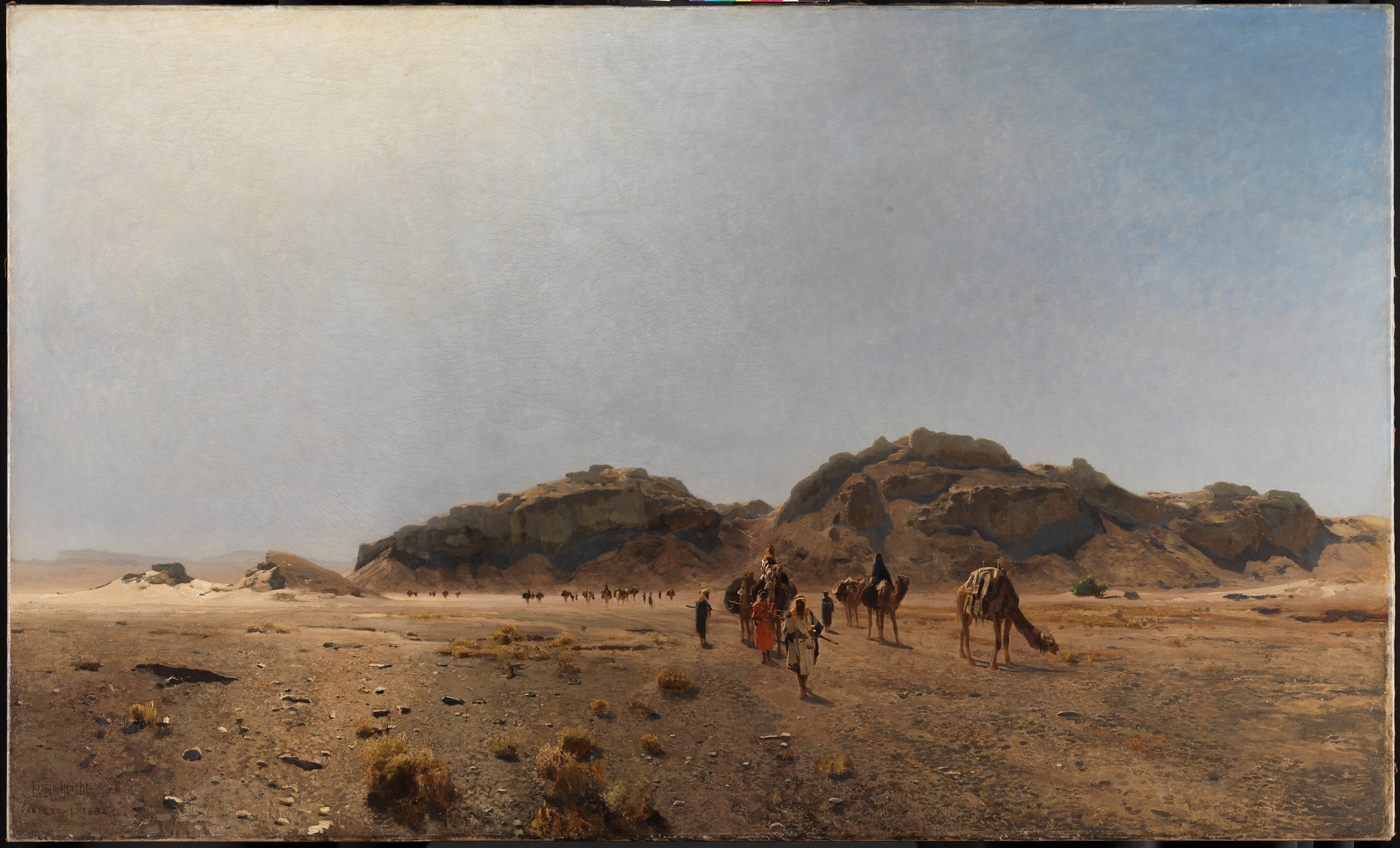 The artwork by the artist Eugen Bracht shows a desert landscape. The painting also shows a group of caravans with camels.
