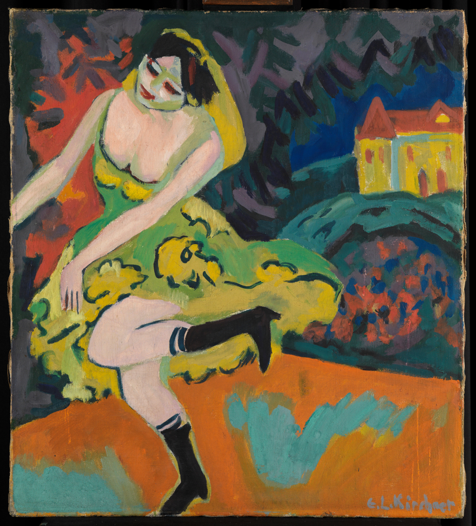 The abstract painting by the expressionist artist Ernst Ludwig Kirchner shows a dancer in a yellow and green dress. Behind her is an abstract colorful landscape with a house.