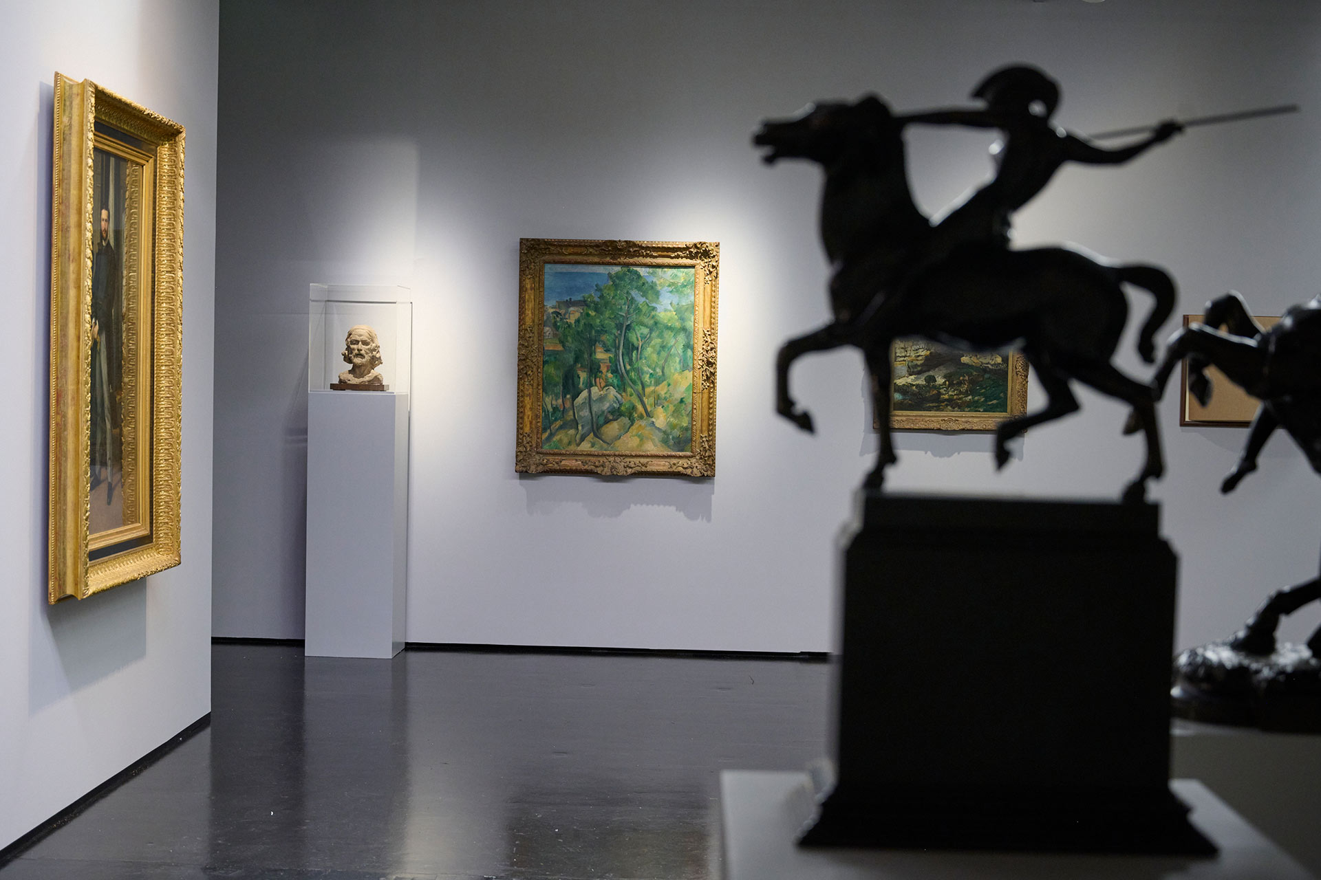 Blick in die Ausstellung KunsthalleKarlsruhe@ZKM neben kleinen Reiterskulpturen im Vordergrund sind im Hintergrund ein Gemälde Cézannes sowie eine Skulptur Rodins zu sehen