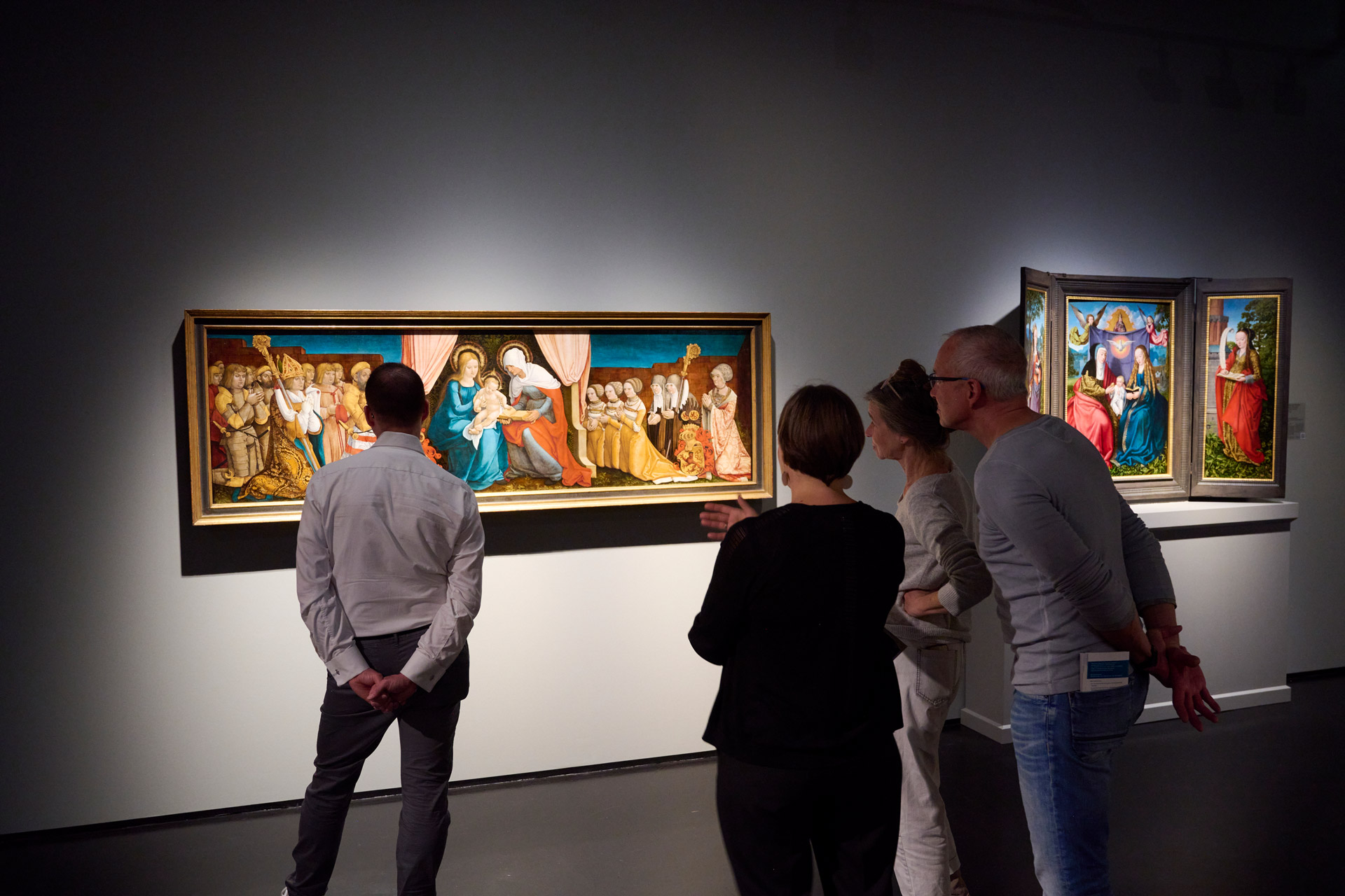 Ausstellungsansicht mit Besucher*innen, die ein Gemälde anschauen.