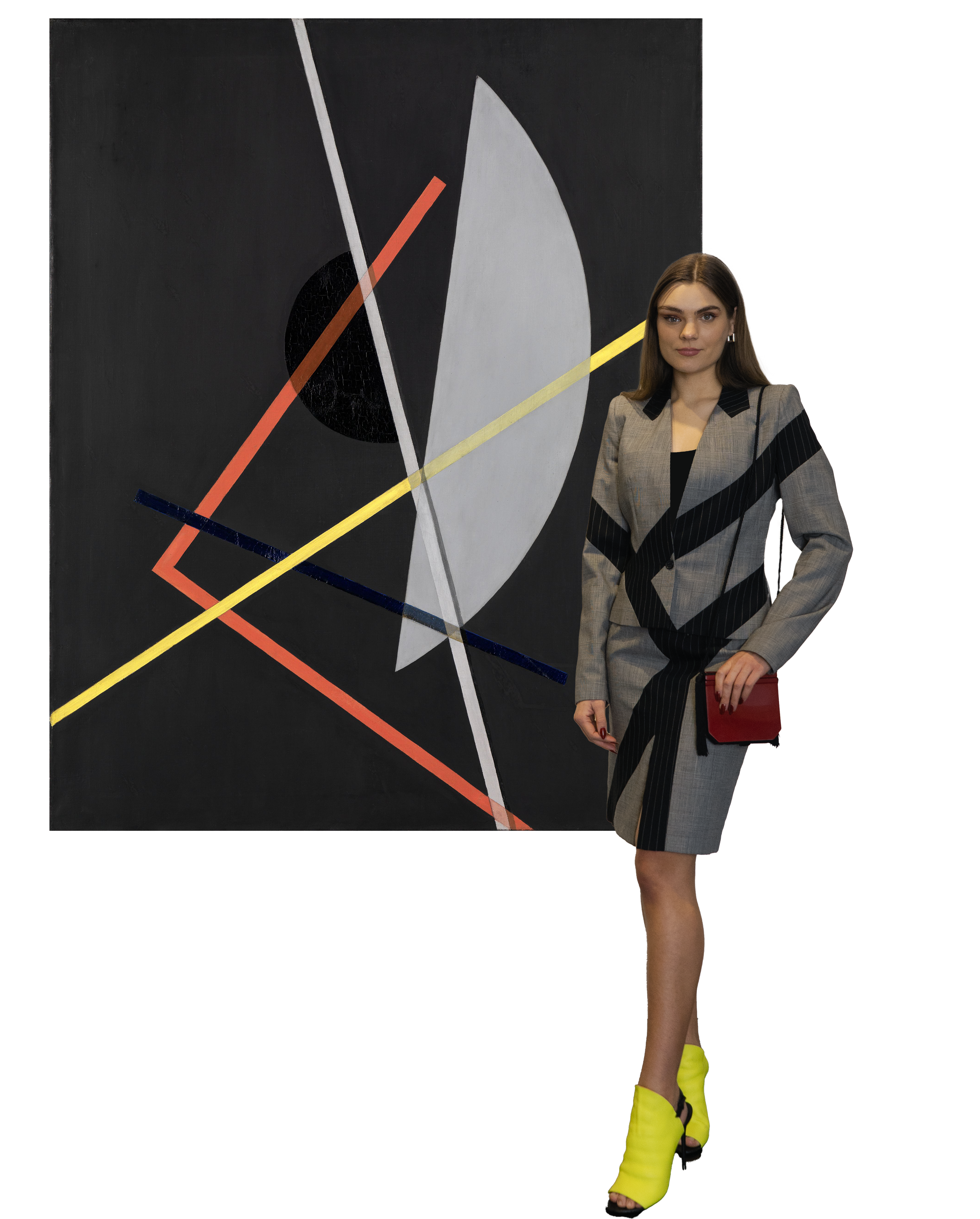 Eine Frau mit einem grauen Kostüm mit schwarzen Streifen und neongelben Schuhen neben dem Werk von Moholy-Nagy, auf dem man verschiedenen geometrische Formen, wie Kreise und Linien sieht.