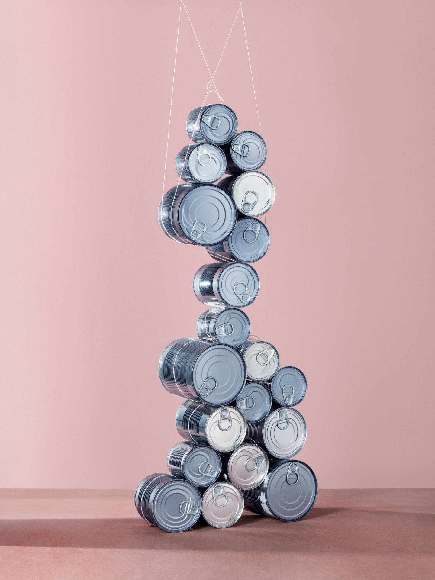 Die zwölf einzelnen Fotografien wie in einem Raster angeordnet. In jedem Bild wird ein Lebensmittel oder Hygieneartikel, wie Klopapier oder Eier, zu einem waghalsigen Konstrukt.