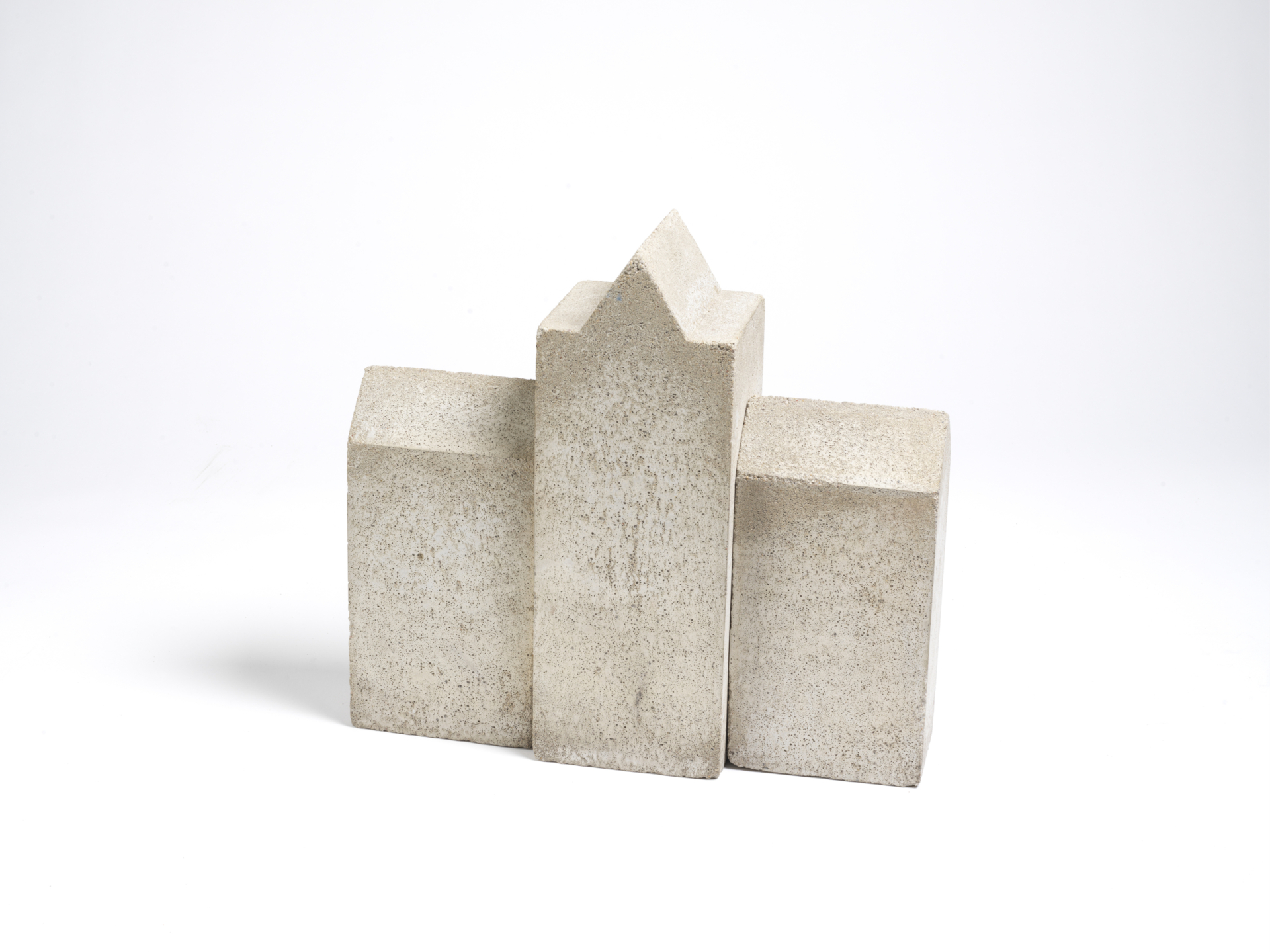 Die Skulptur besteht aus drei Teilen, die wie Bauklötze aussehen. Die beiden äußeren Elemente sind Quader; das Mittlere hat einen Giebel. Alle sind aus Beton.