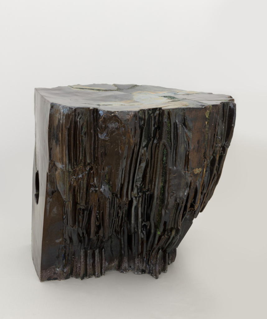 Four sculptures, each about 50 cm high, stand on the floor. They consist of various assembled shapes. Their surfaces are partially smooth and partially rough.