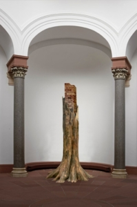 Aus einer artifiziellen Wurzel wächst eine Säule aus Ziegeln hoch in den Raum. Sie erreicht eine Höhe von über vier Metern.